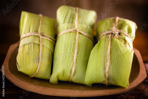 pamonha-Brazilian typical of rural towns. Sweet corn with cheese served in straw. Concept of rural and regional Brazilian food. photo