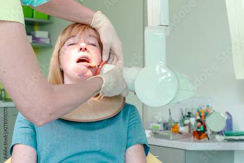 Принти на полотні Dentist adjusting an digital X-ray of oral cavity while patient sitting on chair