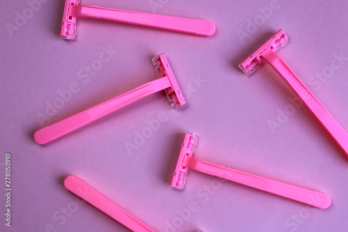 Women`s razors pink color on an pink background.