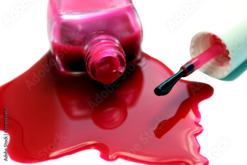 Spilled and open nail polish with a red brush photo