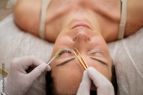 Procedure of eyelash extension in salon by cosmetician