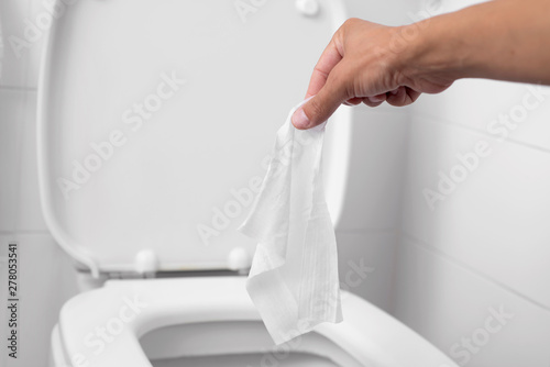 man throwing a wet wipe to the toilet photo