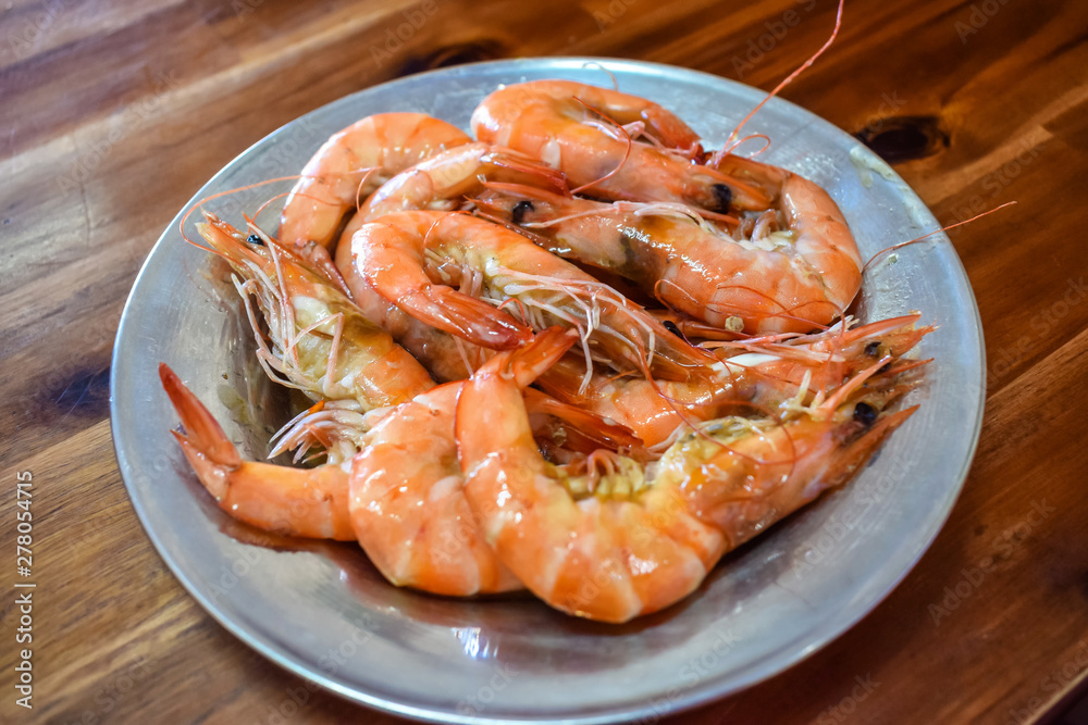 Boiled fresh shrimp on a plate on a wooden table in restaurant Boiled fresh shrimp on a plate on a wooden table in restaurant