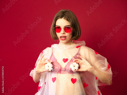 Beautiful young woman with clean perfect skin and big pink lips posing with cotton flower. Portrait of beauty model in red sunglasses, fashion concept