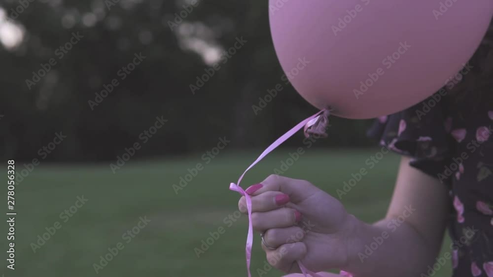 The guy and the girl let go of the inflatable balls in the park