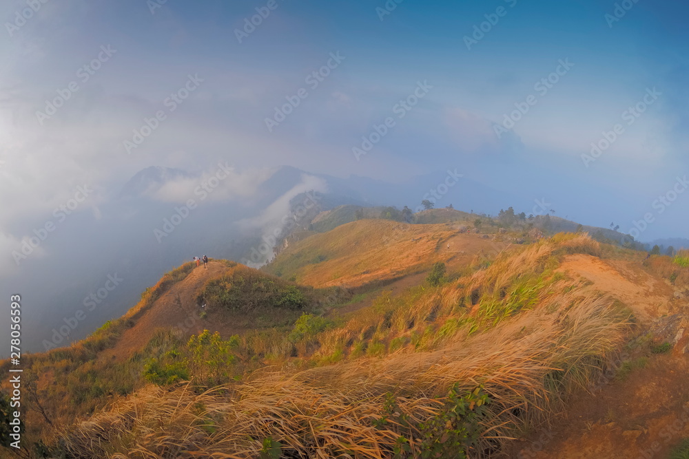 Mountain view of tourists standing on top hill around with mountains, soft mist with cloudy sky background, Phu Chi Fa (Phu Chee Fah), Chiang Rai, northern of Thailand. Mountain view of tourists standing on top hill around with mountains, soft mist with cloudy sky background, Phu Chi Fa (Phu Chee Fah), Chiang Rai, northern of Thailand.