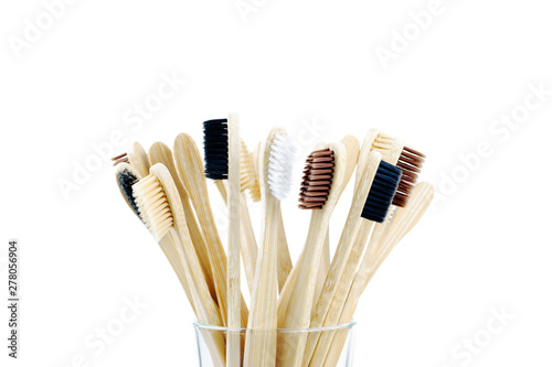 Eco-friendly toothbrushes in a transparent glass on an isolated background close-up. Zero waste concept  conscious consumption  no plastic.