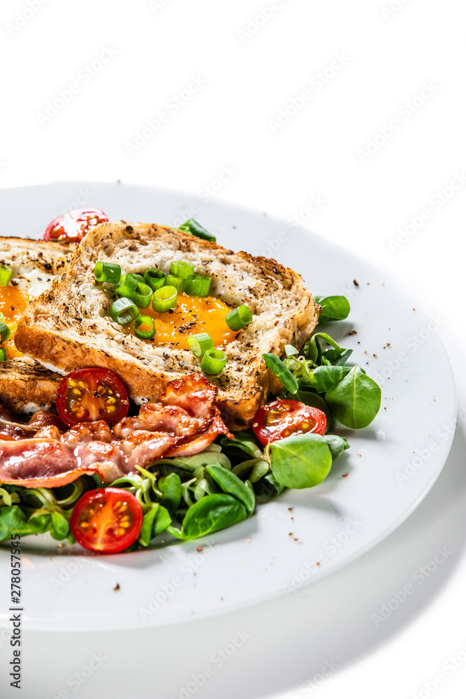 Breakfast - toasted bread with fried egg, bacon and vegetables