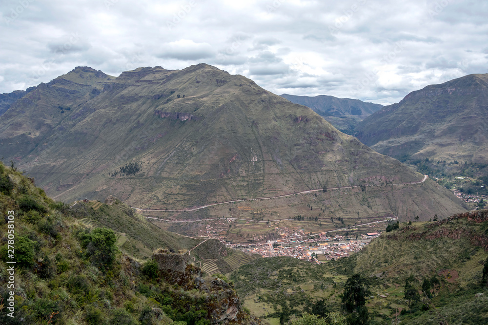 Landscape with green Andean Mountains and Inca ruins on the hiking path in Pisac archeological park, Peru