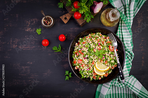 Tabbouleh salad. Traditional middle eastern or arab dish. Levantine vegetarian salad with parsley, mint, bulgur, tomato. Top view