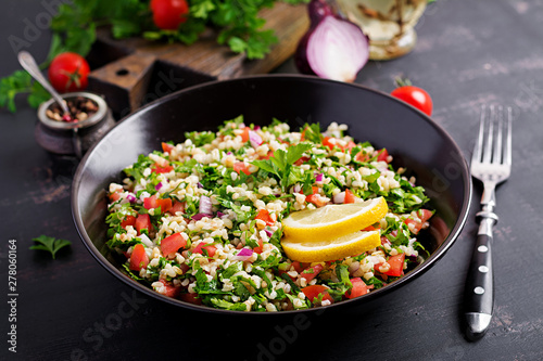 Tabbouleh salad. Traditional middle eastern or arab dish. Levantine vegetarian salad with parsley, mint, bulgur, tomato.