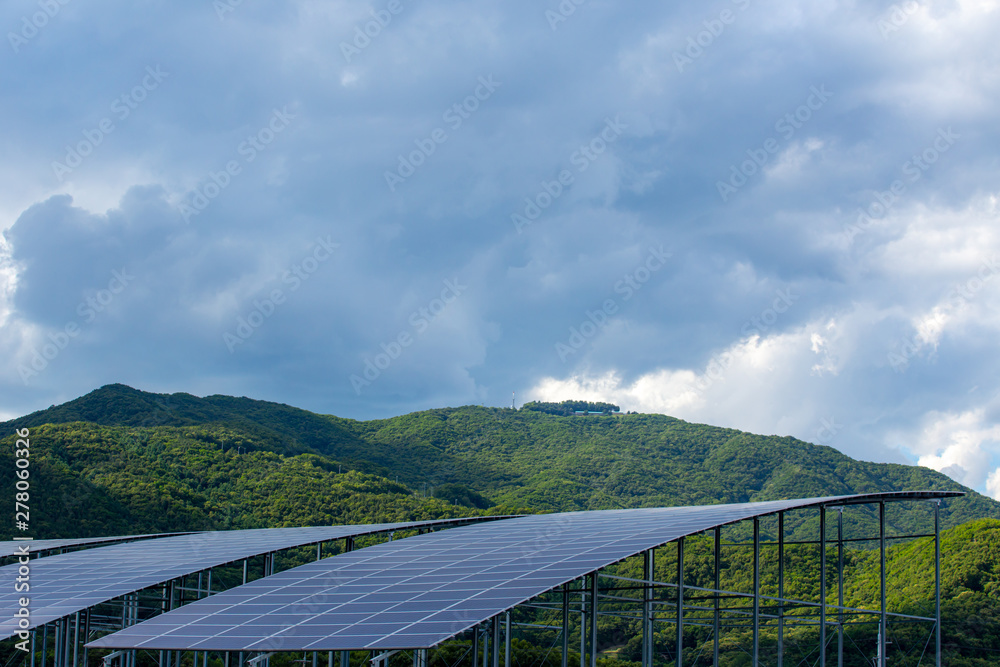 Solar energy panels and green mountain.