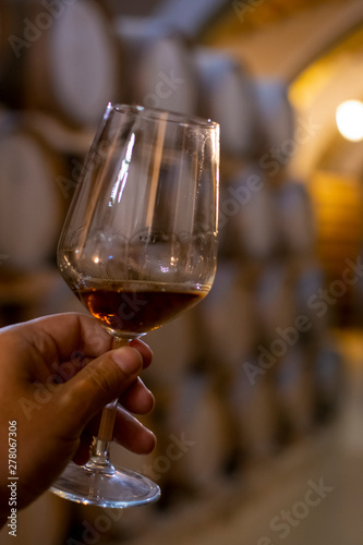 Tasting of fortified dry or sweet marsala wine in vintage wine cellar with old oak barrels in Marsala, Sicily, Italy