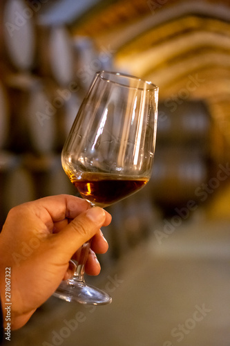 Tasting of fortified dry or sweet marsala wine in vintage wine cellar with old oak barrels in Marsala, Sicily, Italy