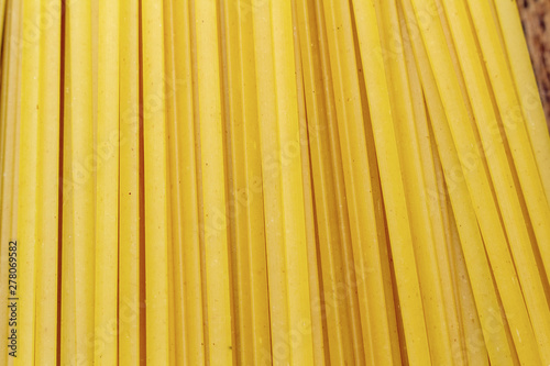 spaghetti, macaroni, pasta, linguine durum wheat Italian thin long on wooden background close up selective focus