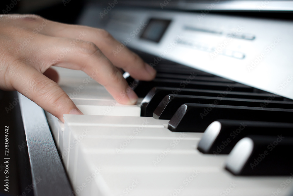 Fototapeta premium Musician playing the piano. Close up to the hand.