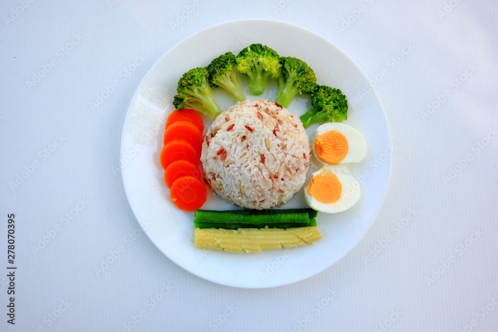 Clean food have brown rice,milk,apple broccoli,carrot,Lentils,Baby corn,and egg in white disc on white background, healthy or vegetarian food concept Top view. 