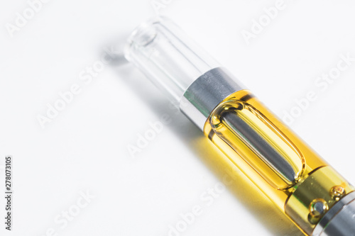 Cannabis oil liquid extract up-close in plastic cartridge, to vape and inhale the medicinal cannabinoids THC & CBD found in marijuana plants. Object isolated on white background