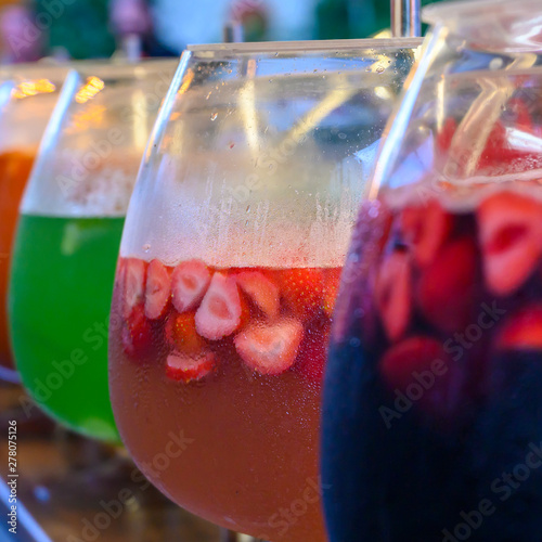 Glasses with punch of various colorful and ice cold fruits.
