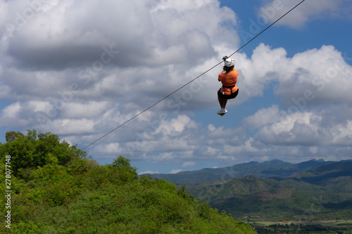 Woman riding in zip line in the Valley of the Sugar Mills in Trinidad Cuba