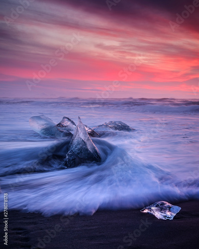 Beautiful sunset over famous Diamond beach, Iceland. This sand lava beach is full of many giant ice gems, placed near glacier lagoon JokulsarlonIce rock with black sand beach in southeast Iceland