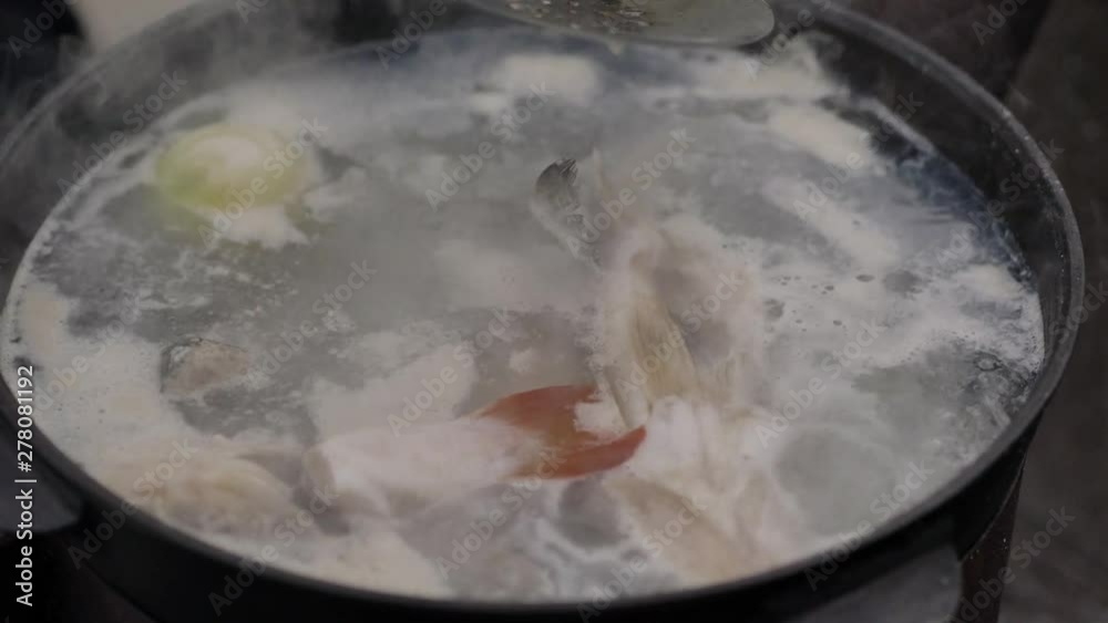 Cooking fish soup outdoors, on the surface of the water foam and plentiful steam, close-up shot, summer Cooking fish soup outdoors, on the surface of the water foam and plentiful steam, close-up shot, summer
