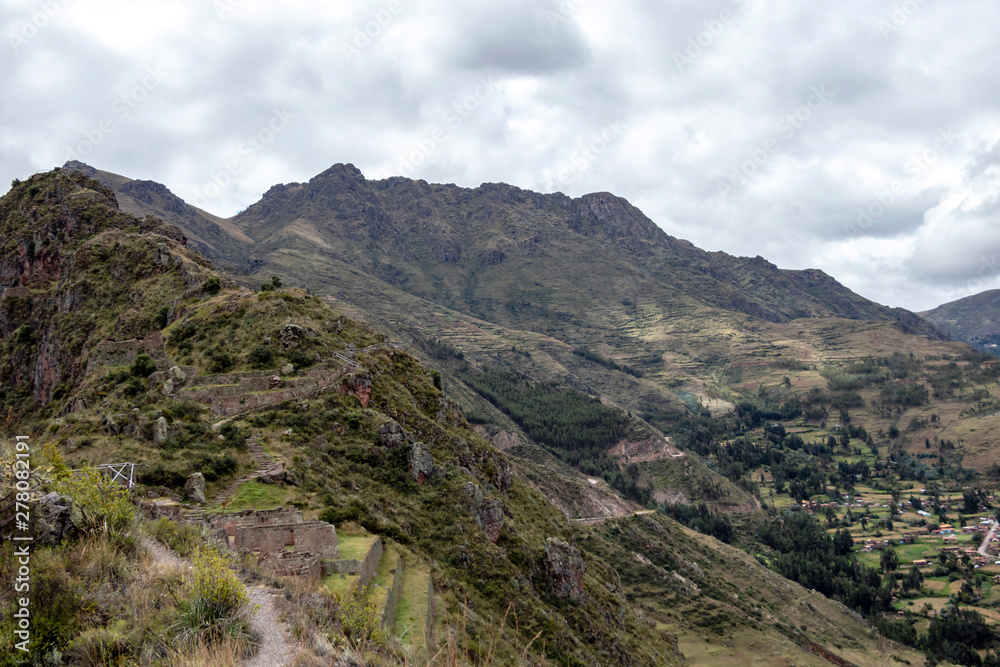 Landscape with green Andean Mountains and Inca ruins on the hiking path in Pisac archeological park, Peru