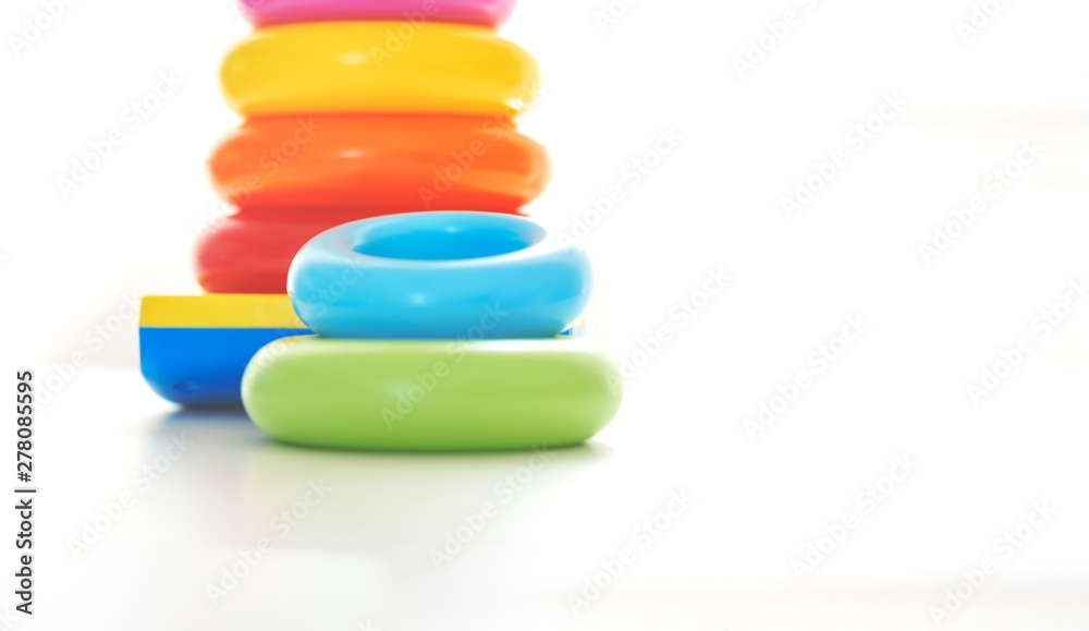 Colorful plastic rings on a white background to be stacked in a tower. Colorful plastic rings on a white background to be stacked in a tower.