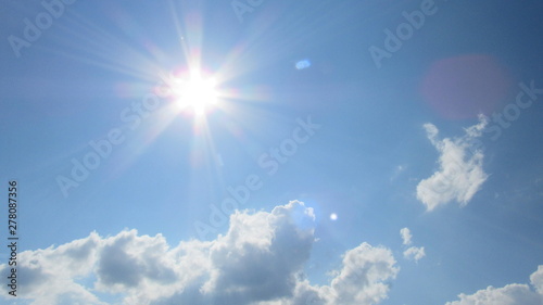 sun on the background of a blue sky with white clouds