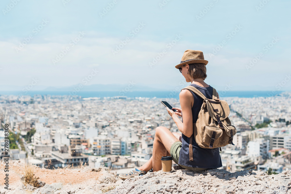 Young woman using smartphone in a big city, travel, lifestyle, tourist destination, technology concept