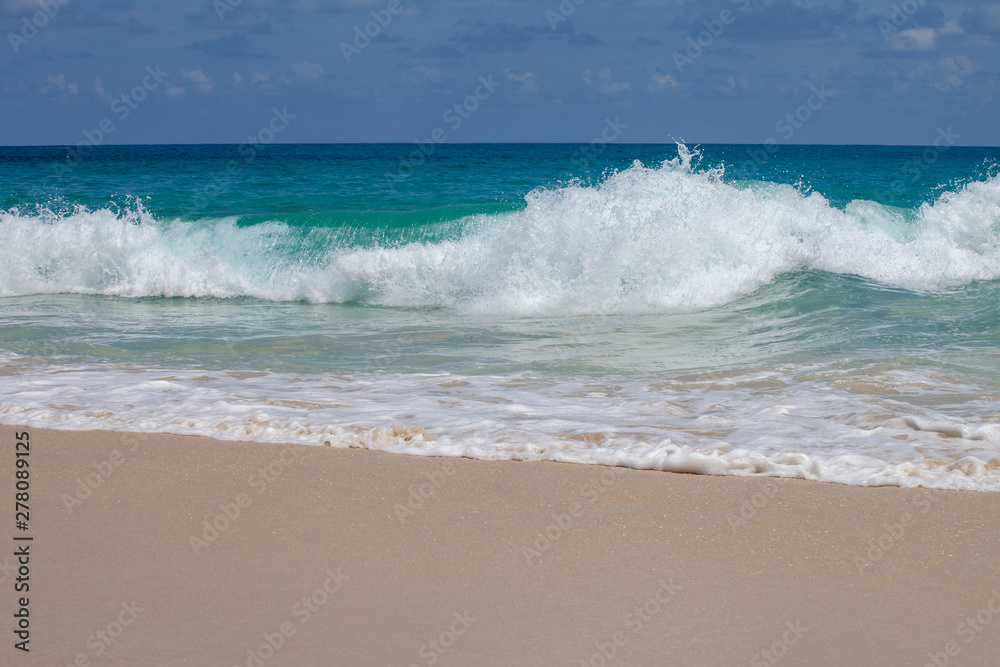 azure sea with waves on a sandy beach