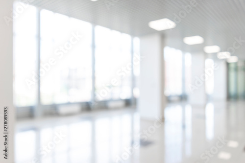 Blurred defocused bokeh background of exhibition hall or convention center hallway. Business trade show modern white interior architecture. Abstract blur modern business office background