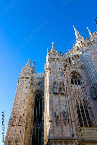 detail of the roof of gothic cathedral in milan, largest church in Italy with blue sky on the background