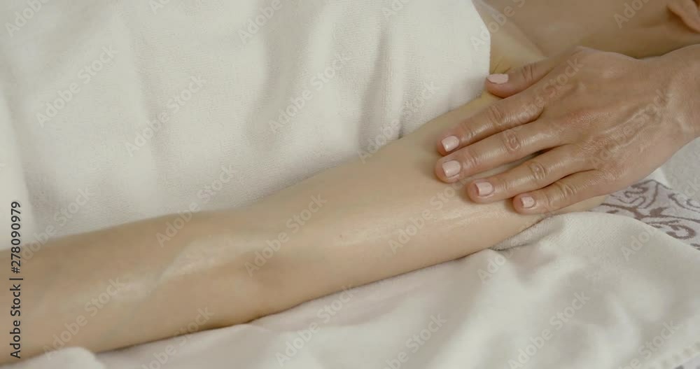 masseur is stroking arm of client during oil relaxing massage, detail view masseur is stroking arm of client during oil relaxing massage, detail view