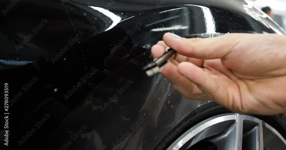 Close up to PPF installation process on a front headlight and hood. PPF
