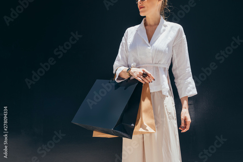 Unrecognisable stylish woman holding shopping bags.