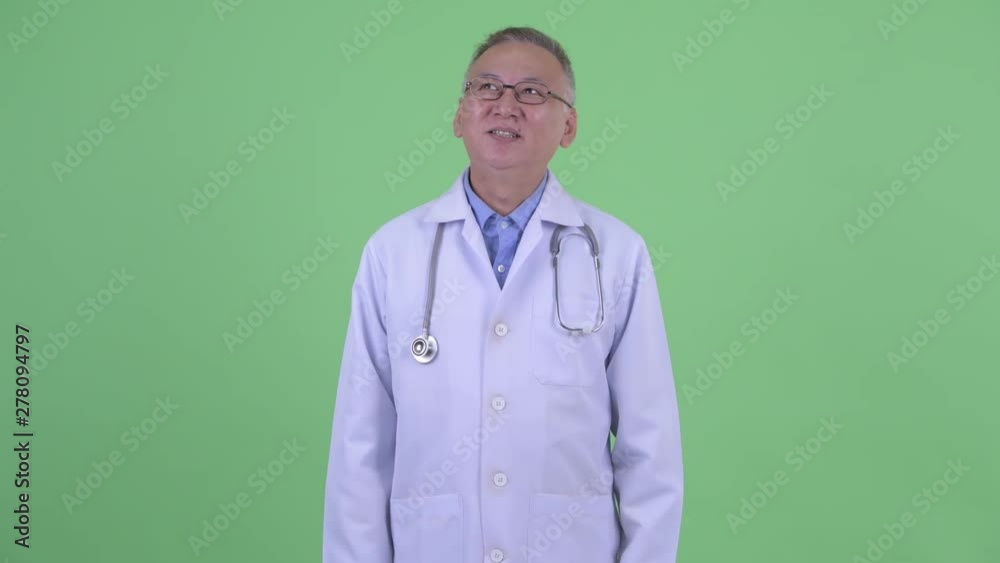 Happy mature Japanese man doctor looking around Happy mature Japanese man doctor looking around