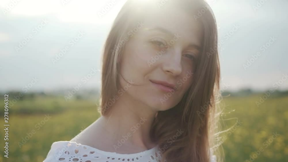 Face attractive young woman stand look at camera smile flower feel freedom blooming yellow field sunset happy meadow green landscape sunlight model portrait close up slow motion Face attractive young woman stand look at camera smile flower feel freedom blooming yellow field sunset happy meadow green landscape sunlight model portrait close up slow motion