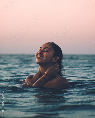 woman holding her neck in body of water