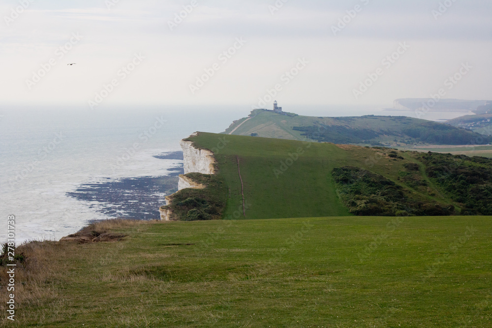 White chalk cliffs and Beachy Head Lighthouse. Eastbourne, East Sussex, England. Highest chalk sea cliff in Britain, rising to 162 metres. Third most common suicide spot in the world