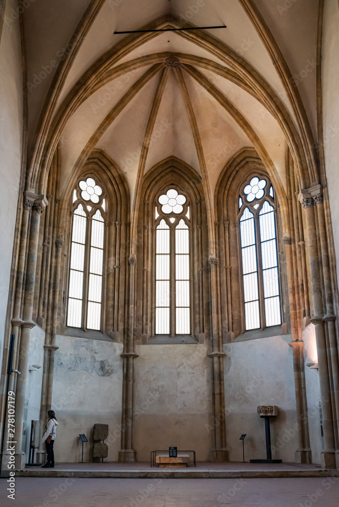 Tourist inside empty room of medieval cathedral