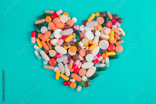 Heart made of colorful pills on blue background, Heart disease medications, Drugs for Heart Disease
