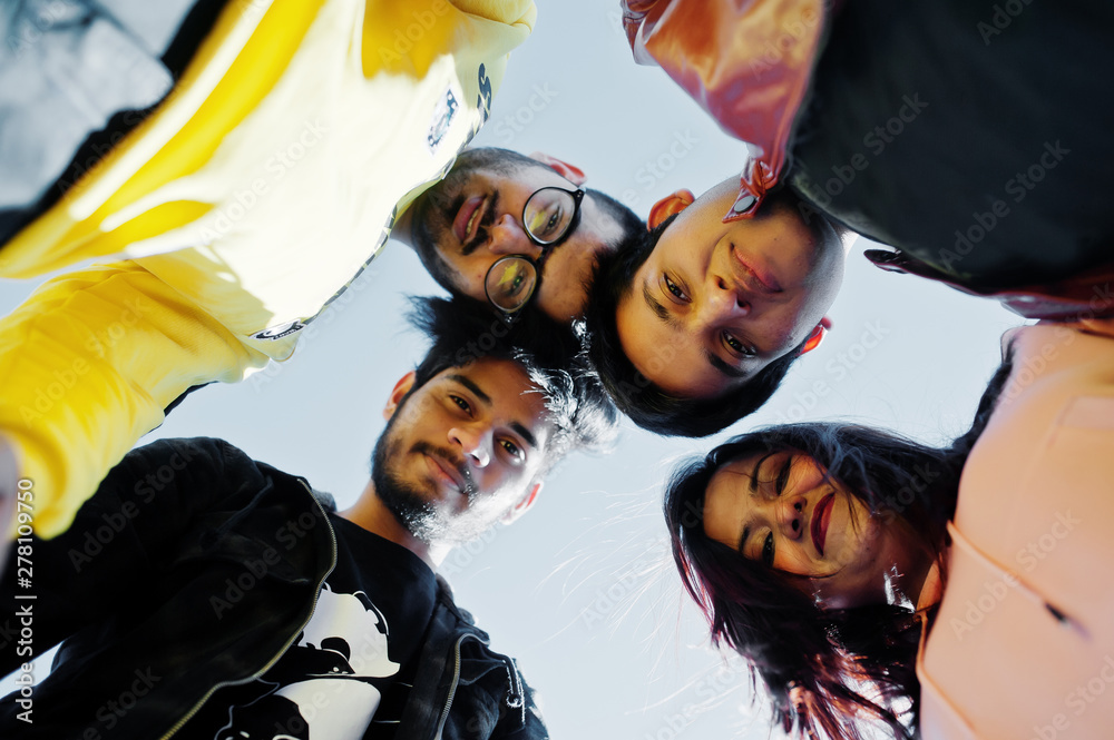 Group of four asian people friends stand on and looking at camera down.