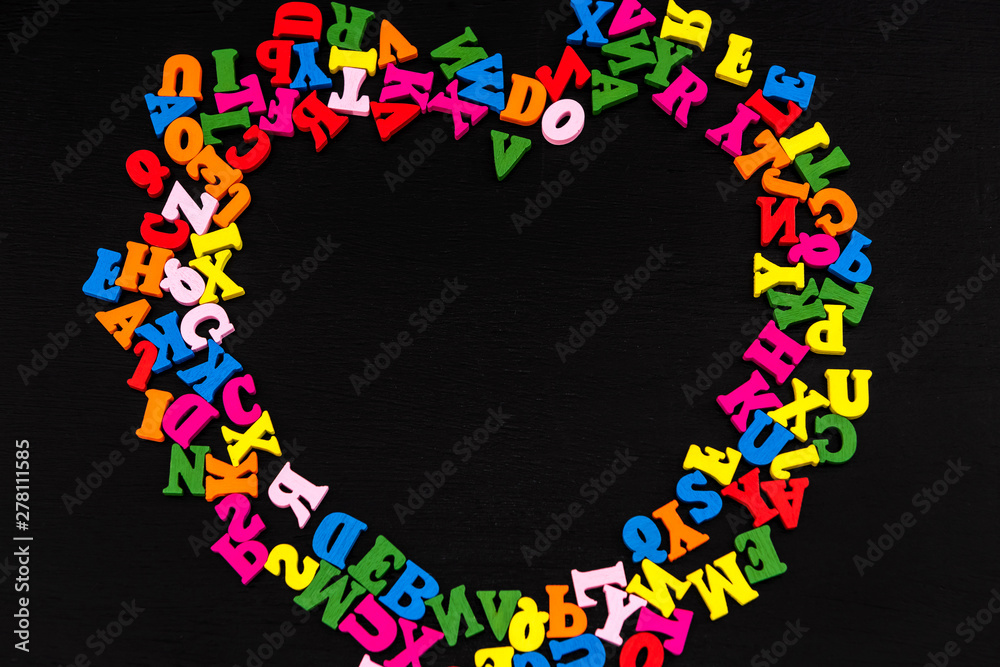 Letter in the form of hearts on black wood background