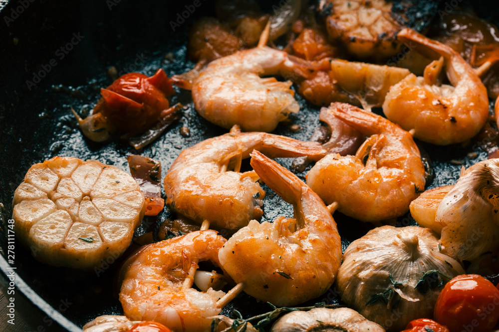 Shrimps on wooden picks fried with cloves of garlic Shrimps on wooden picks fried with cloves of garlic