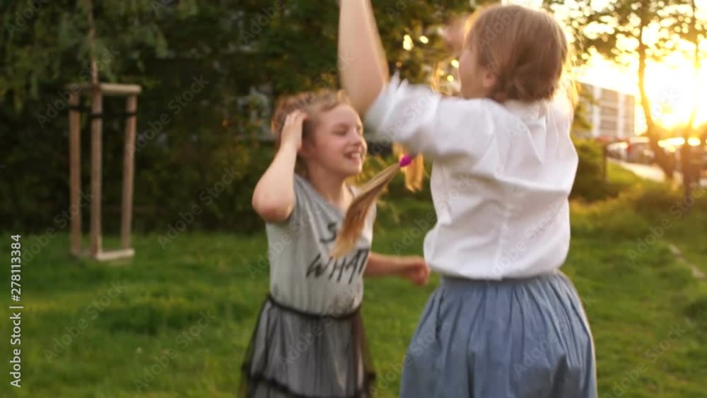 Two teen girls jumping for joy, summer holidays, happy childhood, back to school, outdoor portrait Two teen girls jumping for joy, summer holidays, happy childhood, back to school, outdoor portrait