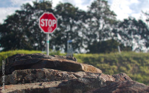 Creative photo of Stone wall with blurred background with stop sign