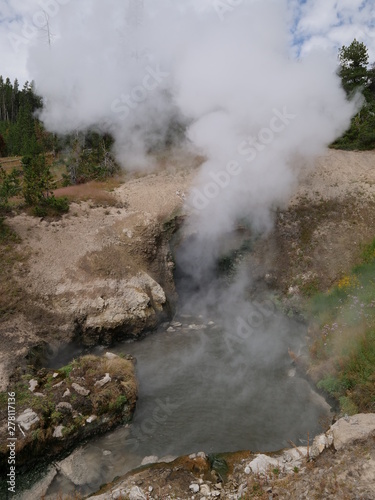 The Dragon's Mouth Spring sloshing out hot water and steam in and out of the cavern at Yellowstone National Park.
