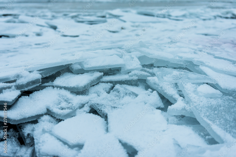 Shards of cracked ice on shore of frozen lake