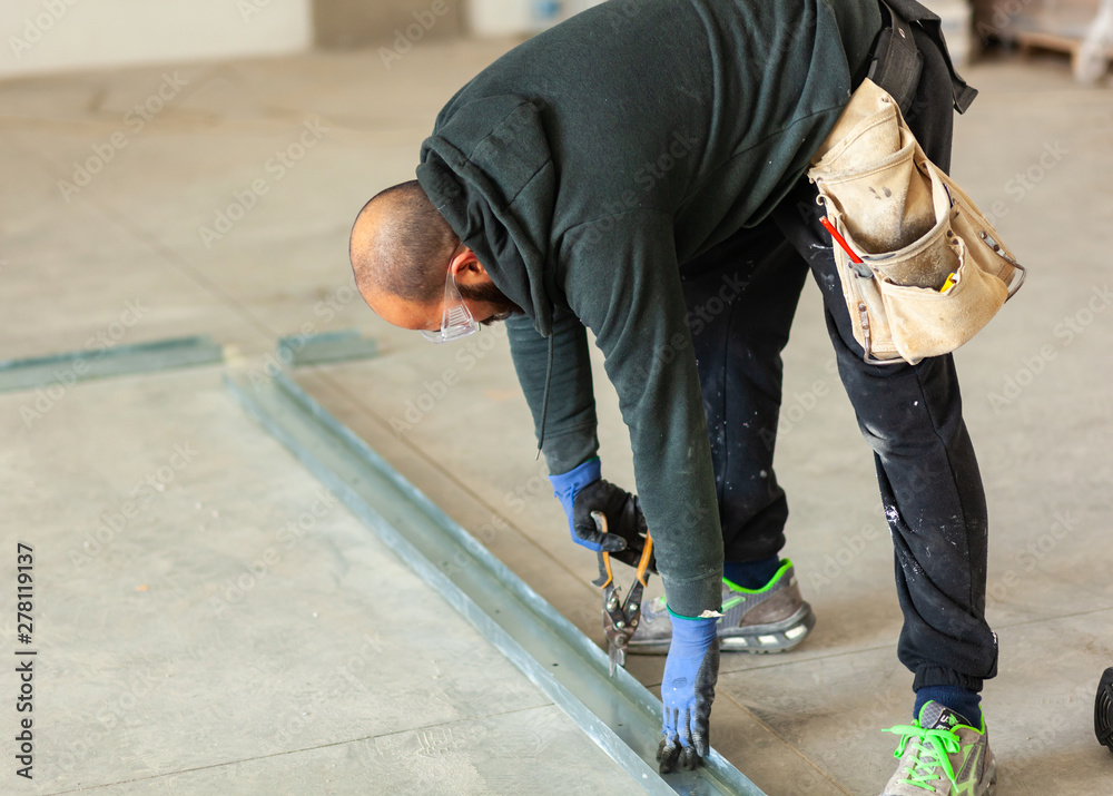 Worker builds a plasterboard wall. Worker builds a plasterboard wall.